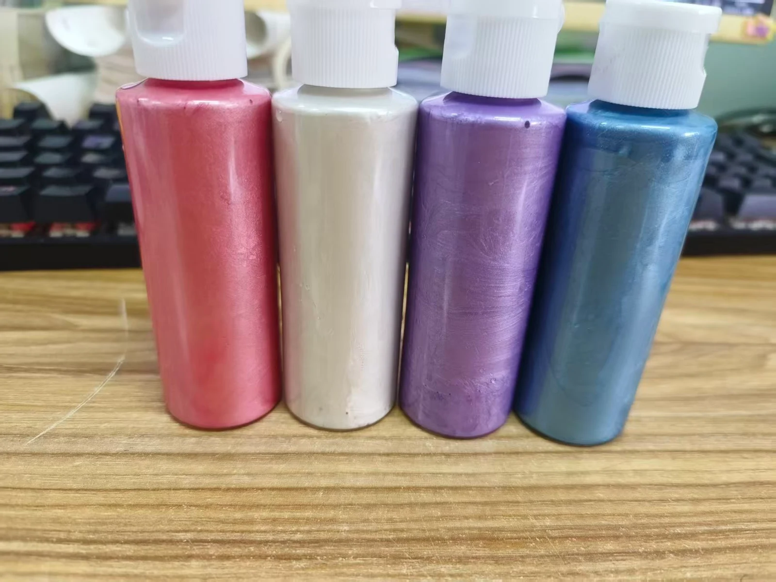 Original photograph of pink, pearl white, purple and blue custom metallic acrylic paint bottles
